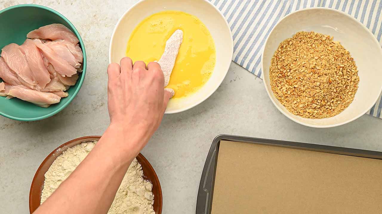 dipping the chicken strips in the egg wash
