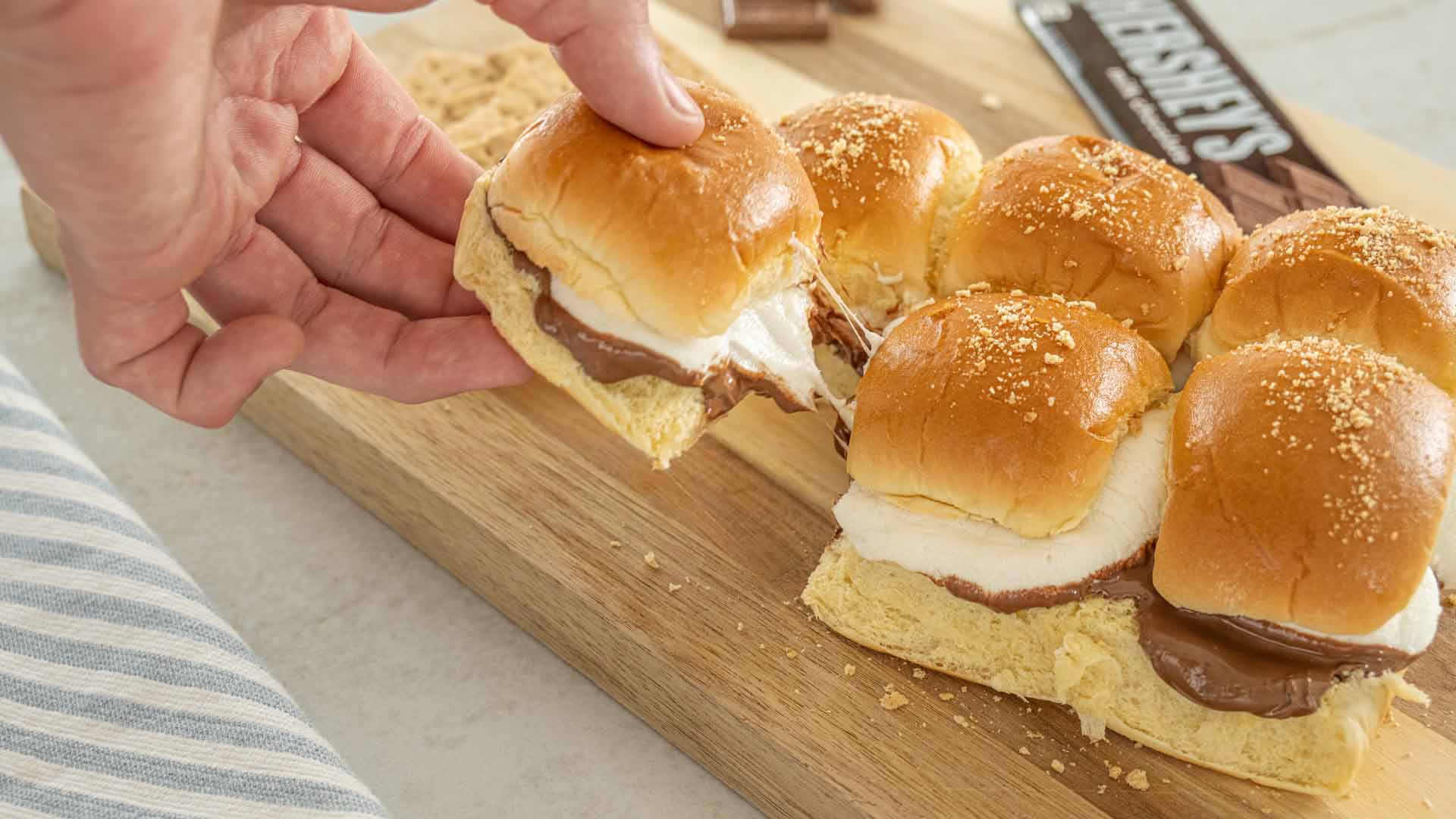 person picking up smores slider from a tray