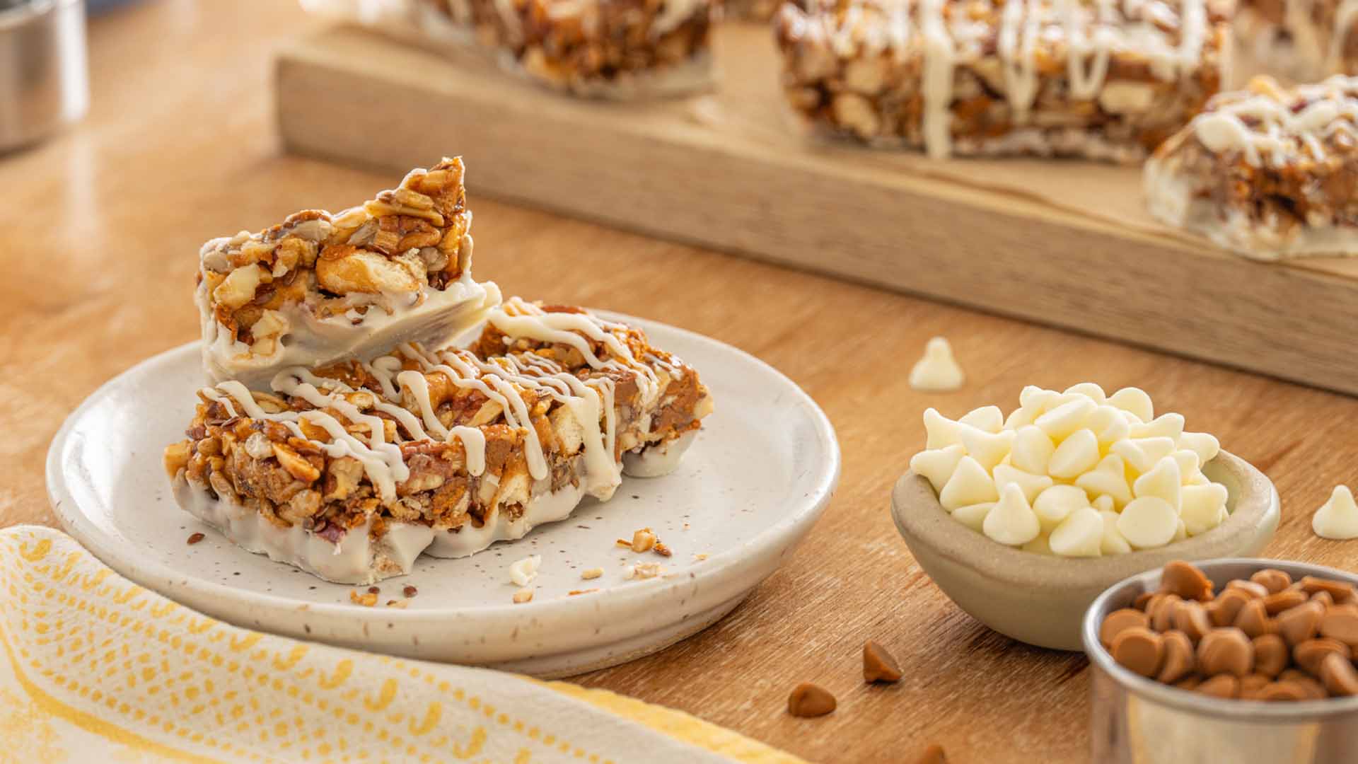 plate and tray of dots apple cinnamon nut bars beside bowls of baking chips