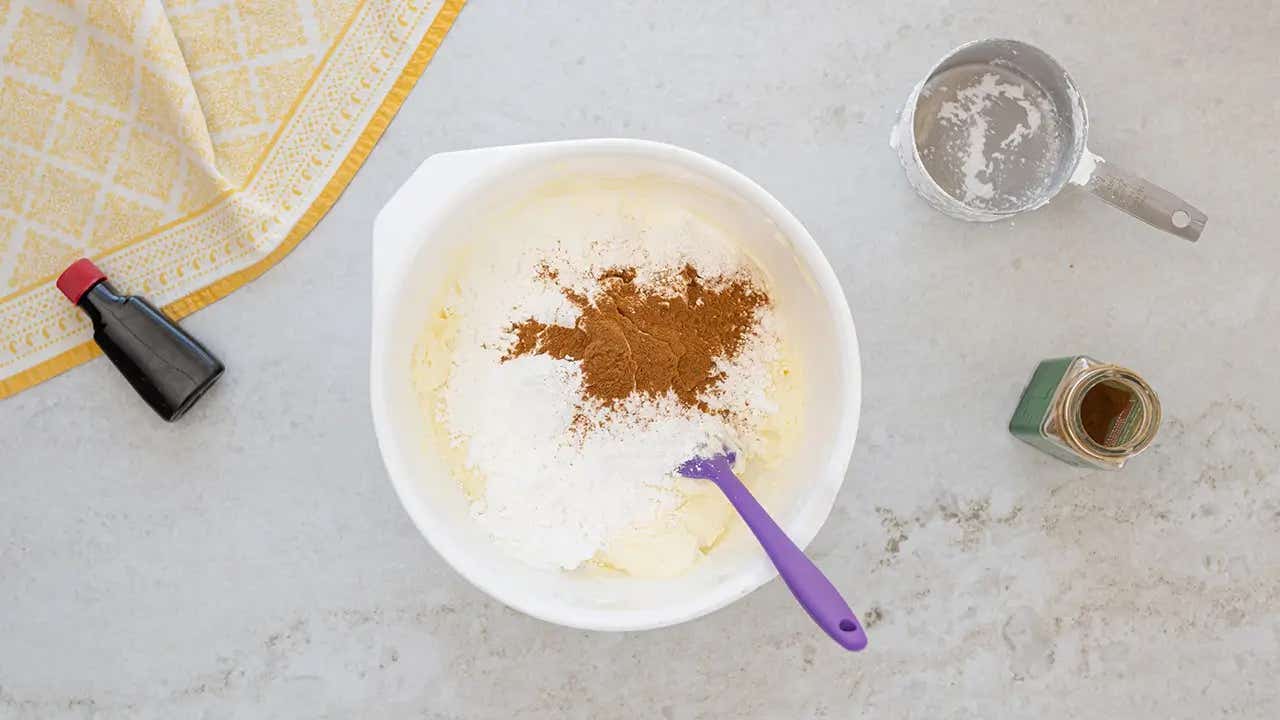 mixing powdered sugar, cinnamon, and vanilla together in a bowl