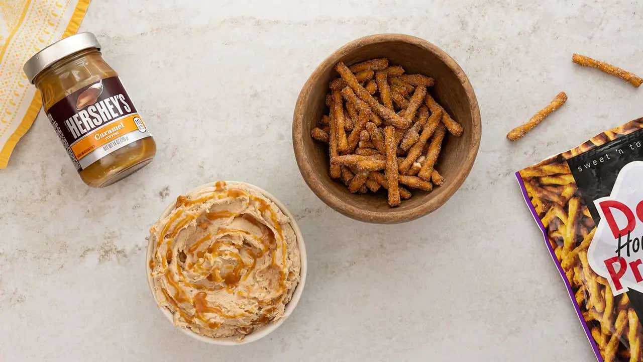 adding caramel topping to the dip and preparing to serve
