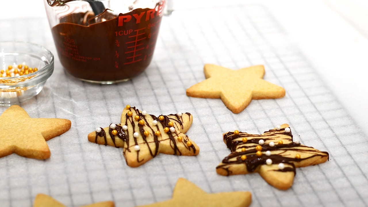 sugar cookie stars being drizzled with chocolate