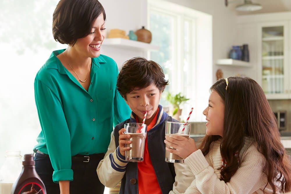 family smiling while drinking chocolate milk