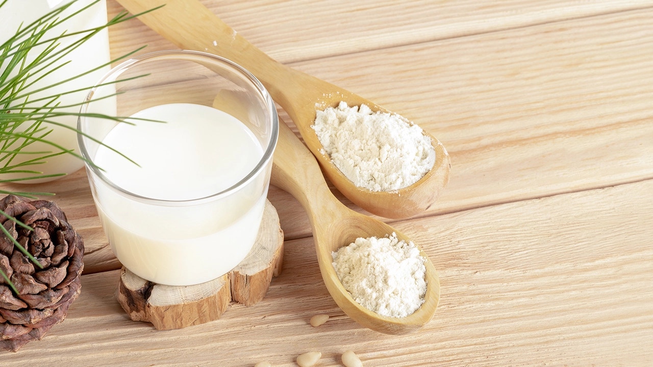 spoons of milk powder and a glass of milk