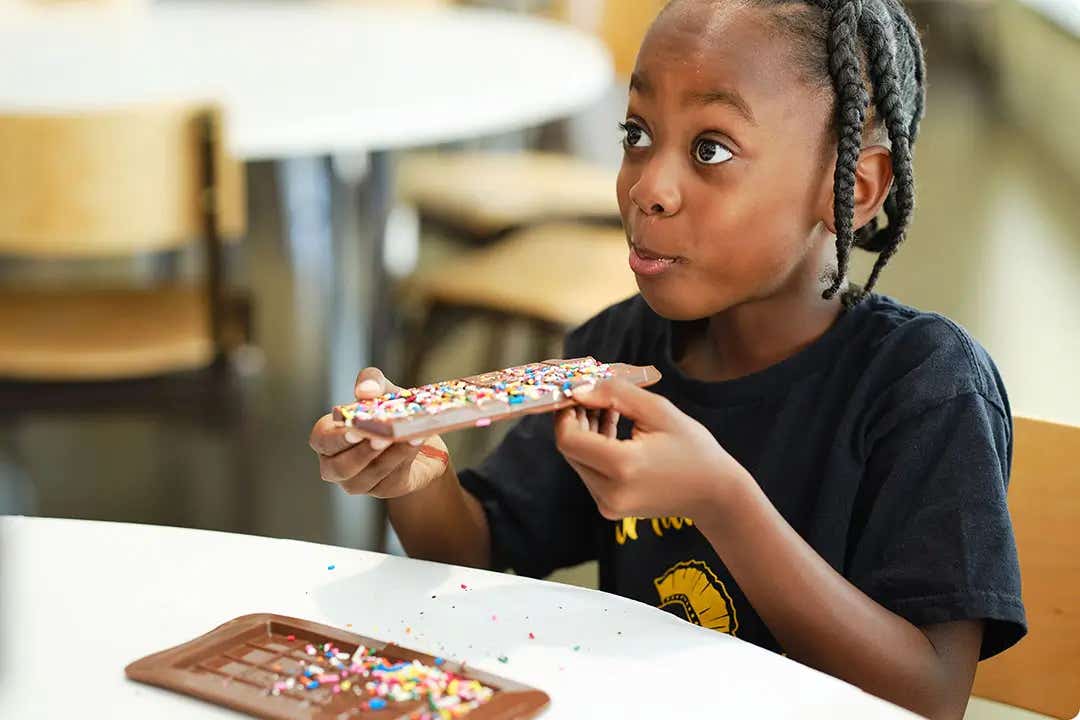 student eating their custom hersheys chocolate bar