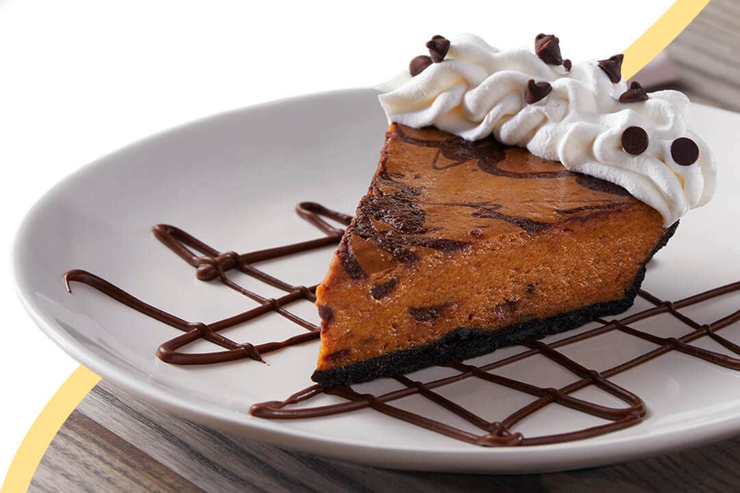 slice of pumpkin pie plated on top of chocolate drizzle