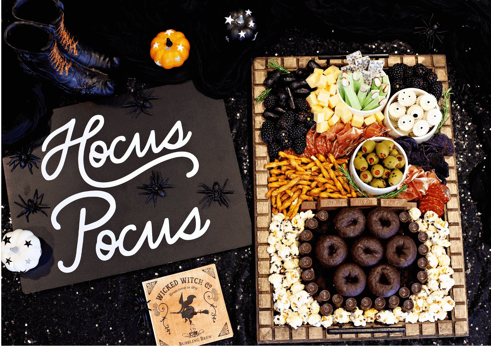 Charcuterie board filled with Halloween snacks surrounded by decorations