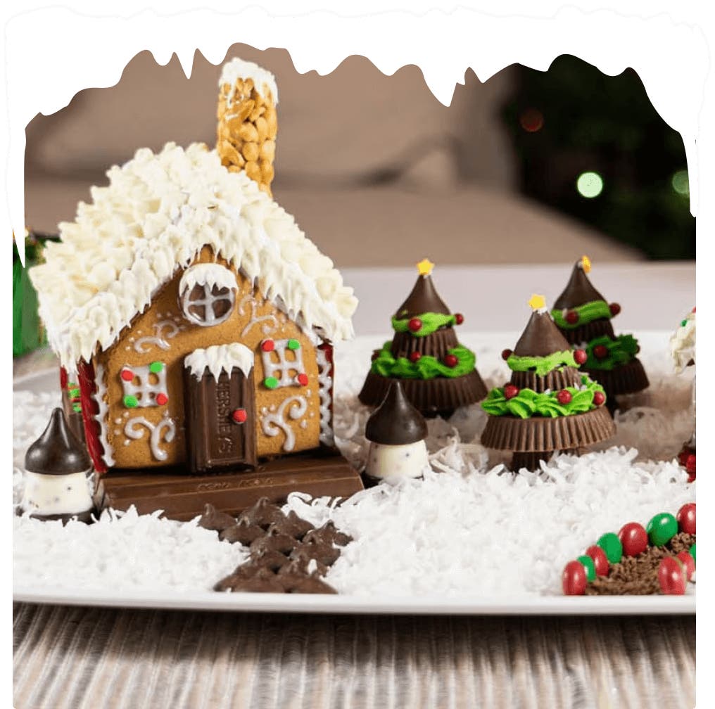 gingerbread houses decorated with frosting and assorted hersheys candy