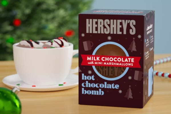 hersheys milk chocolate hot chocolate bomb next to mug of hot cocoa