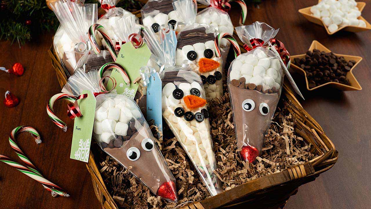 tray of homemade reindeer and snowman themed holiday hot chocolate gift bags
