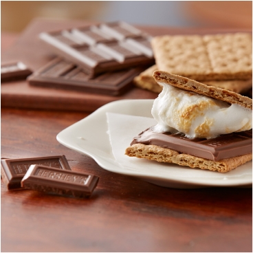 freshly made smores beside smores ingredients