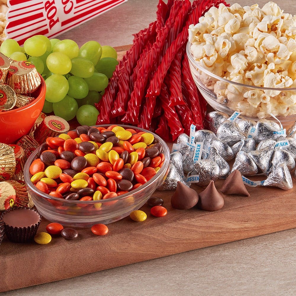 snack board filled with popcorn, grapes, and hersheys candy