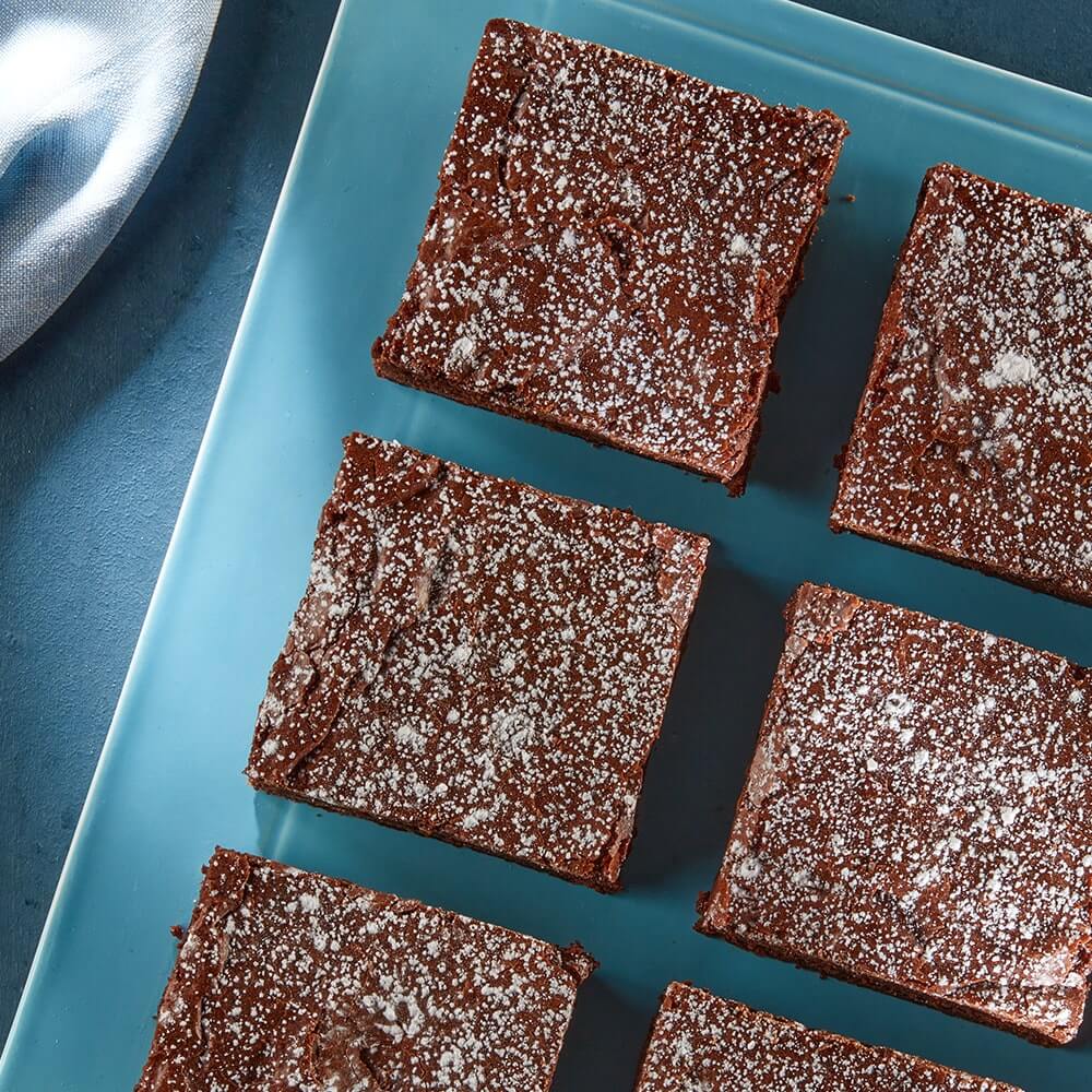 brownies dusted with powdered sugar organized on serving plate