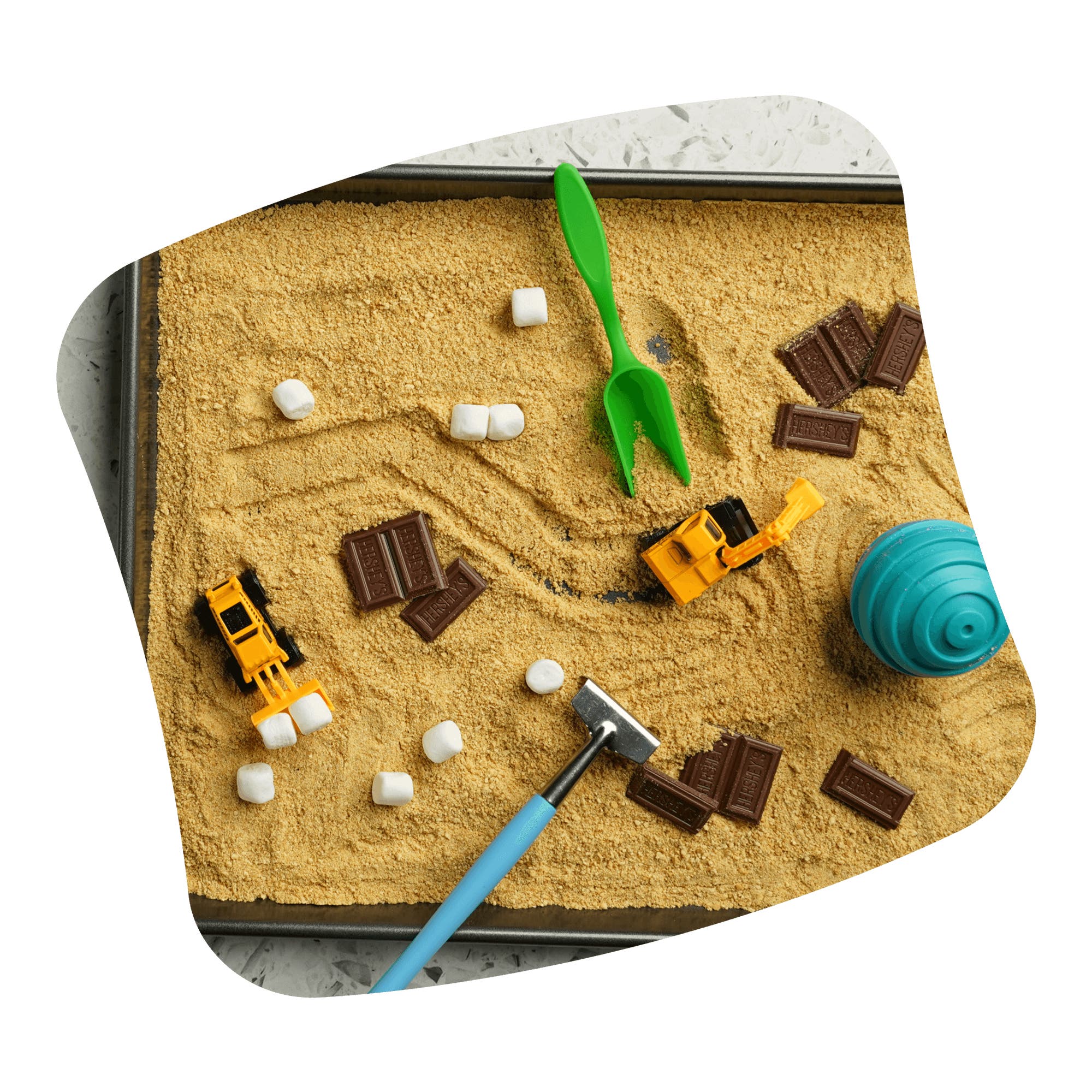 smores sensory bin with graham cracker sand chocolate bar pieces and marshmallows and toys