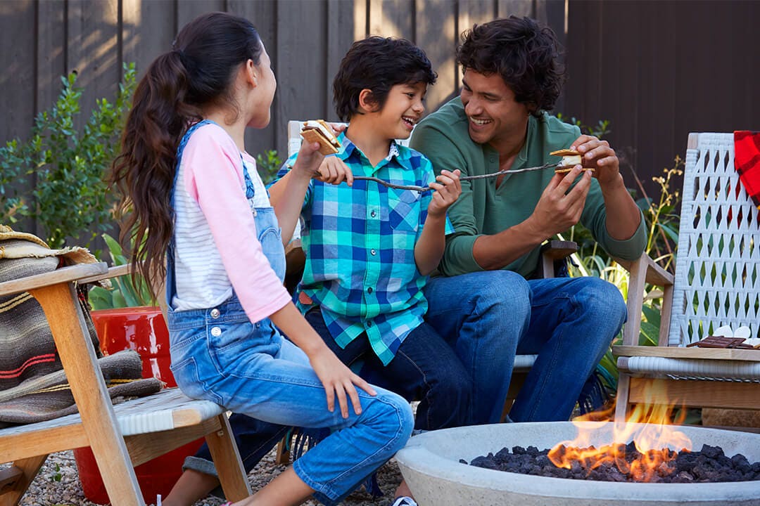 family making and enjoying fire pit smores