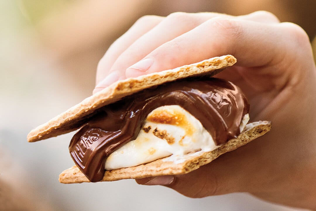 person holding a freshly made hersheys smore