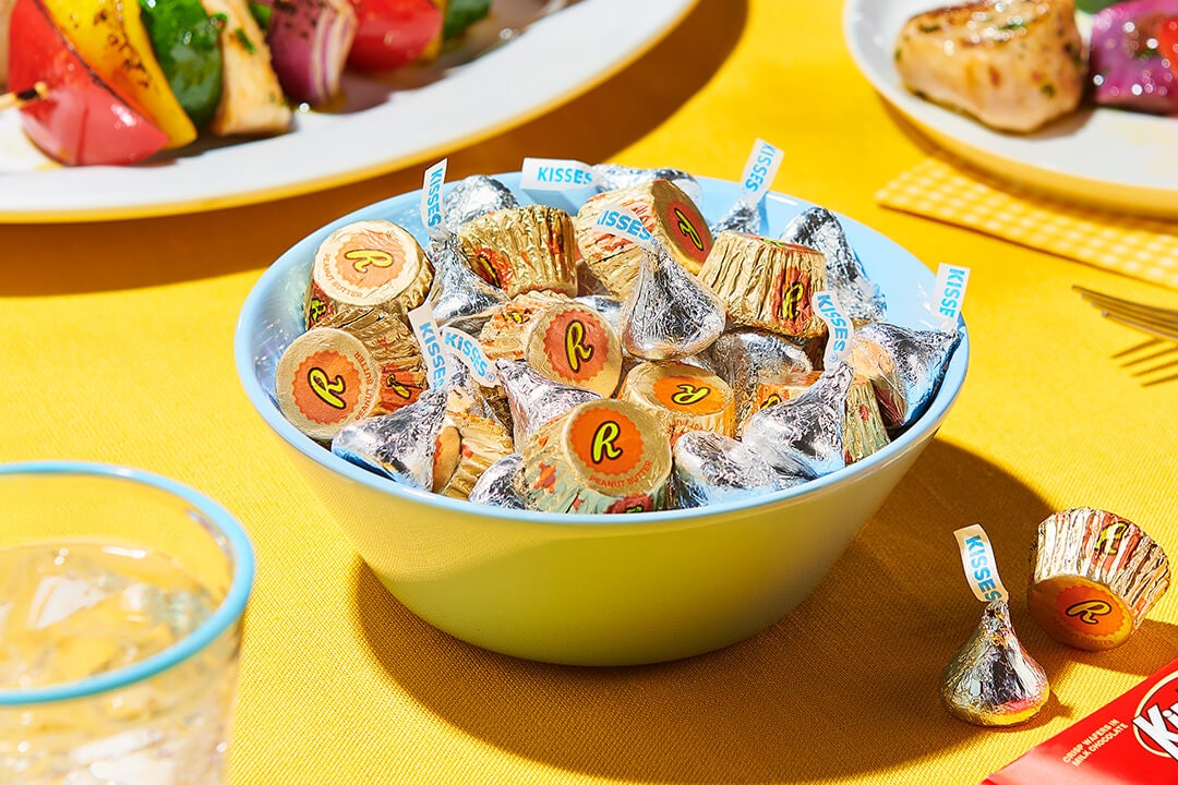 bowl full of assorted hersheys candy beside grilled foods