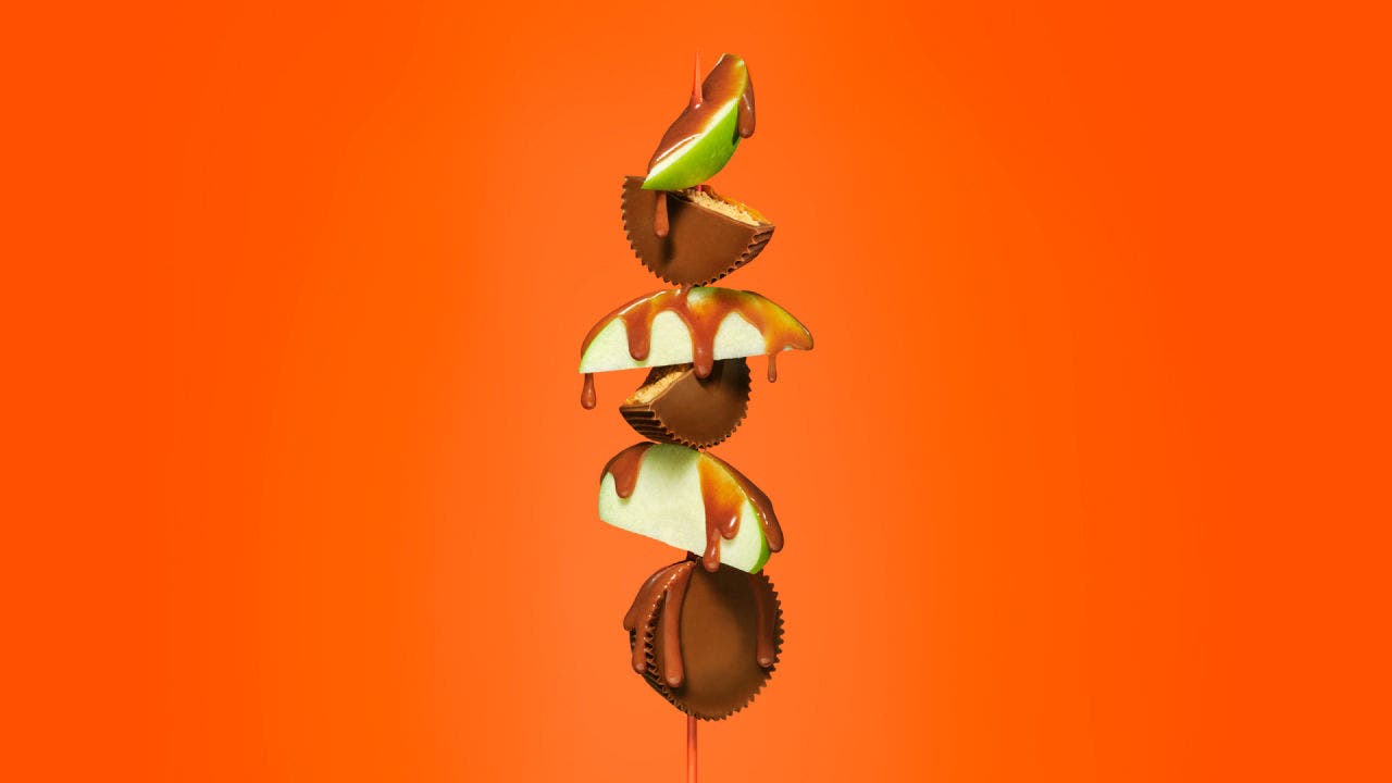 sliced apples and reeses caramel cups on skewer topped with caramel