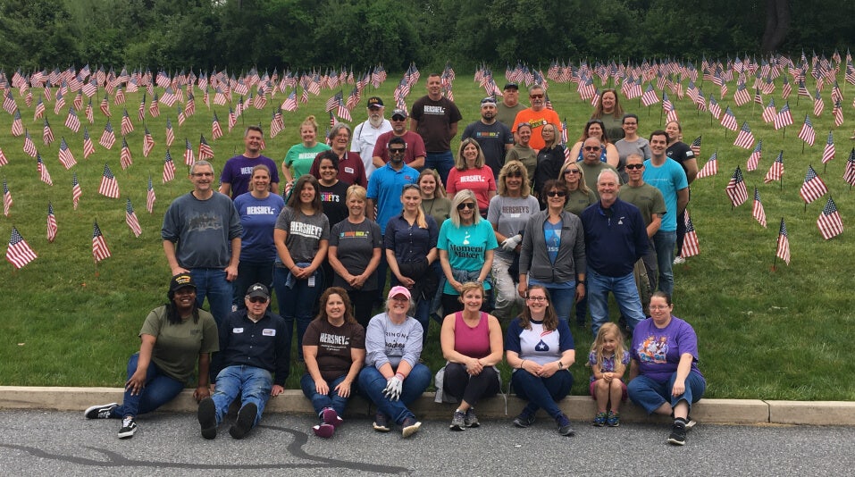 hersheys veterans employee group in front of a field of memorial flags