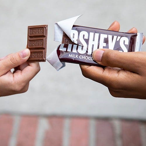 Hand breaking off a piece of Hershey's Chocolate