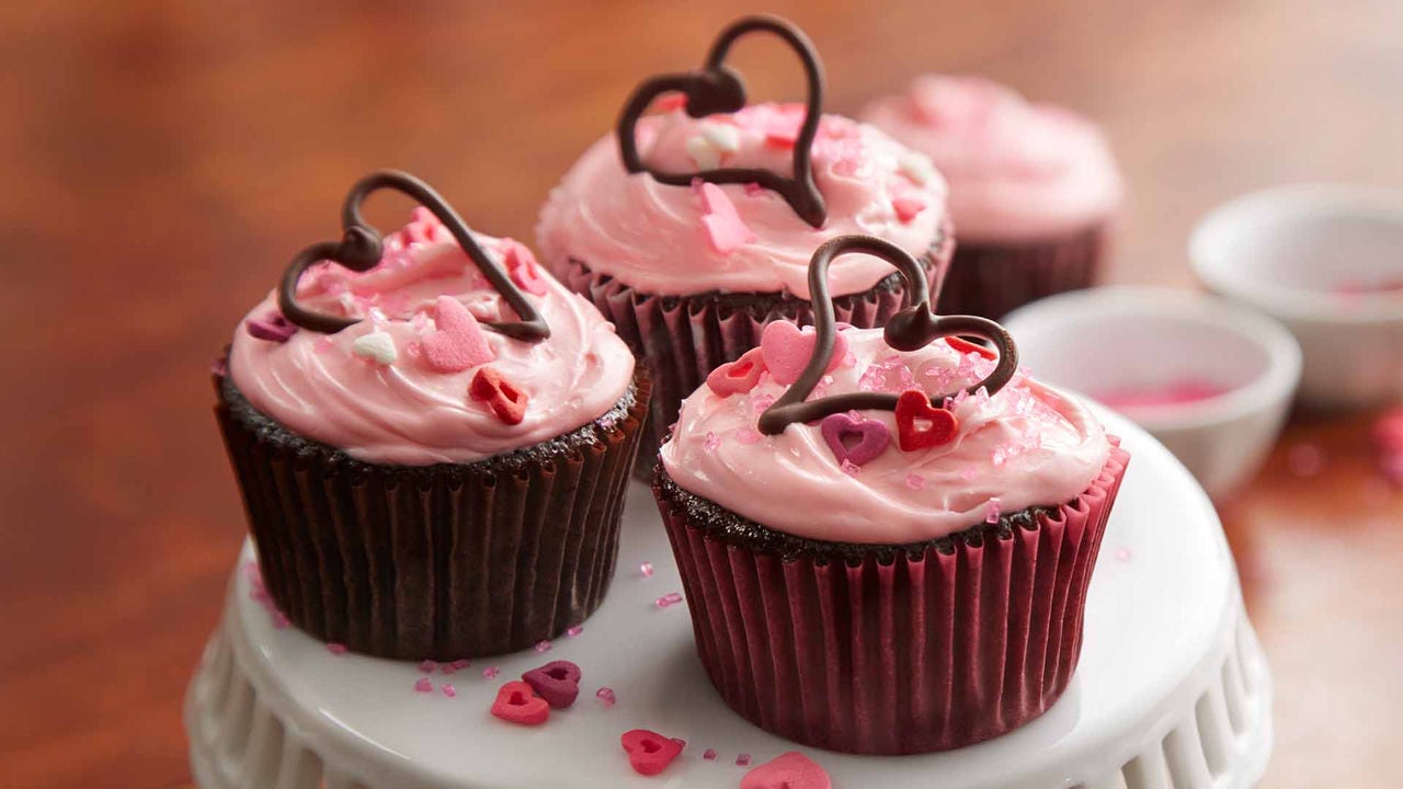 chocolate cupcakes with pink icing and topped with chocolate hearts
