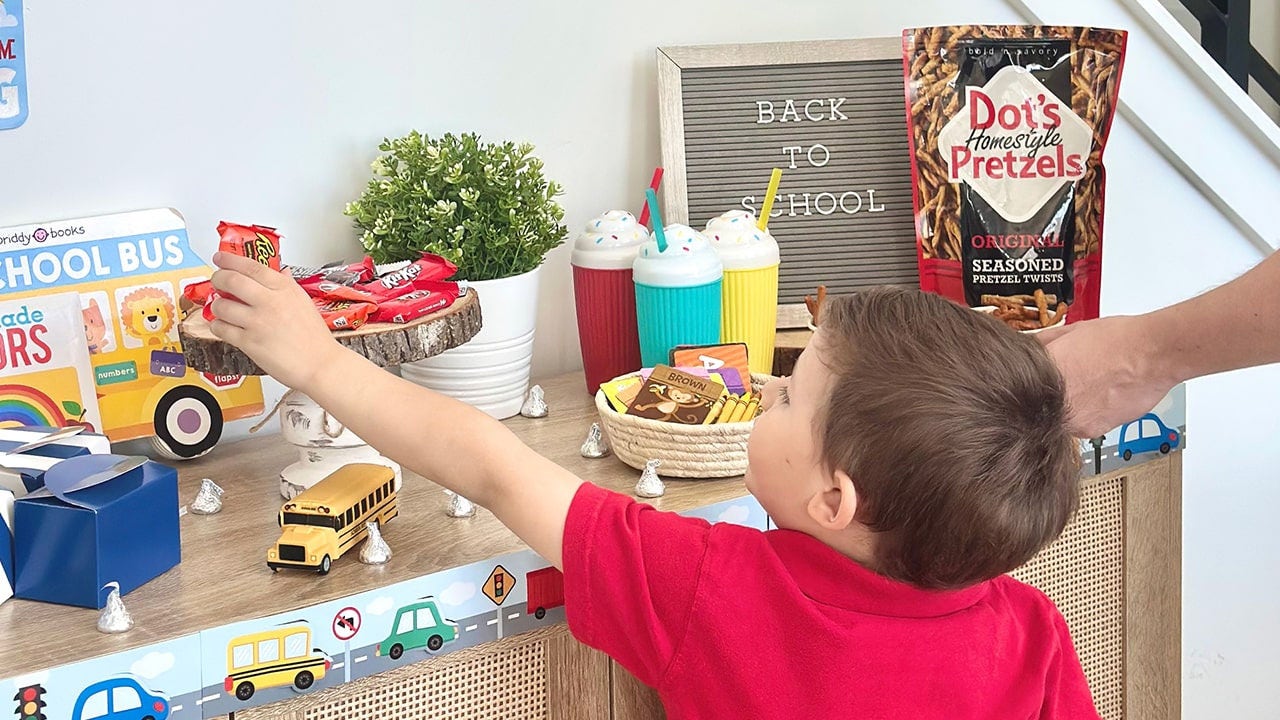 child grabbing candy from tray on table