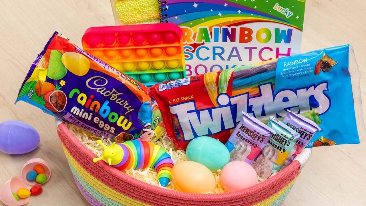 rainbow themed basket filled with hersheys candies, toys, activities, and easter eggs