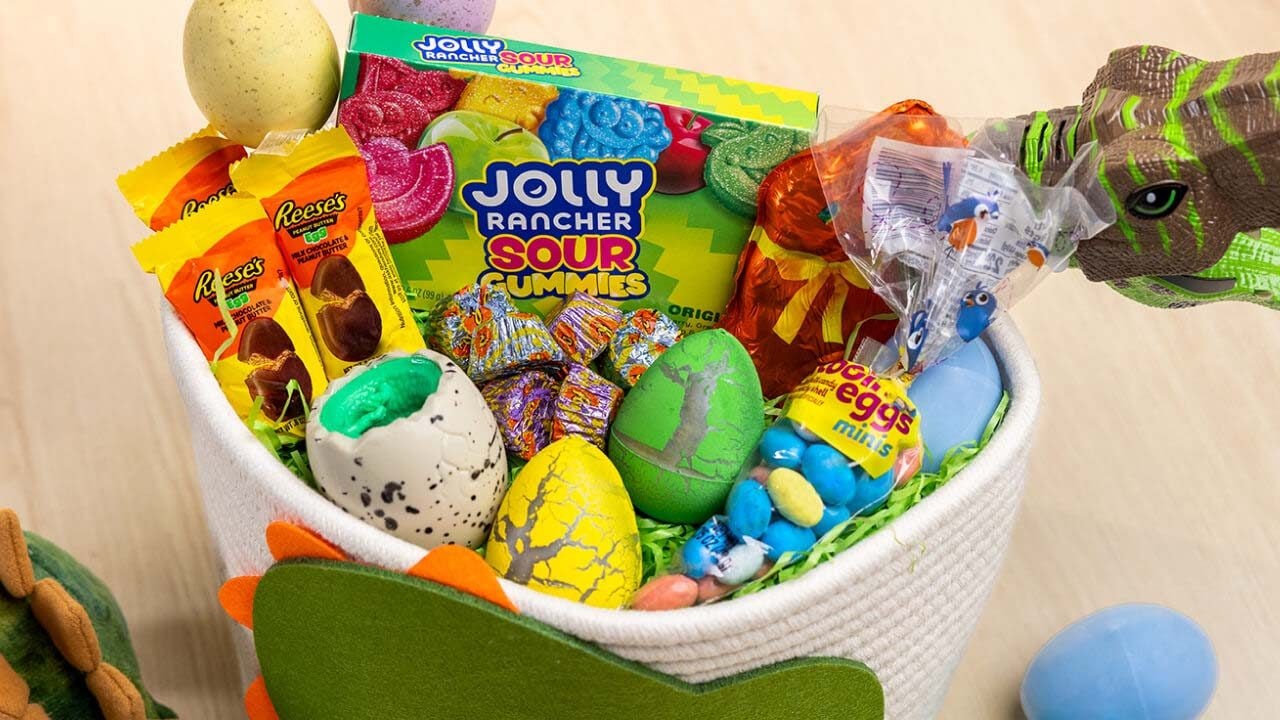 dinosaur themed basket filled with hersheys candies, eggs, and toys
