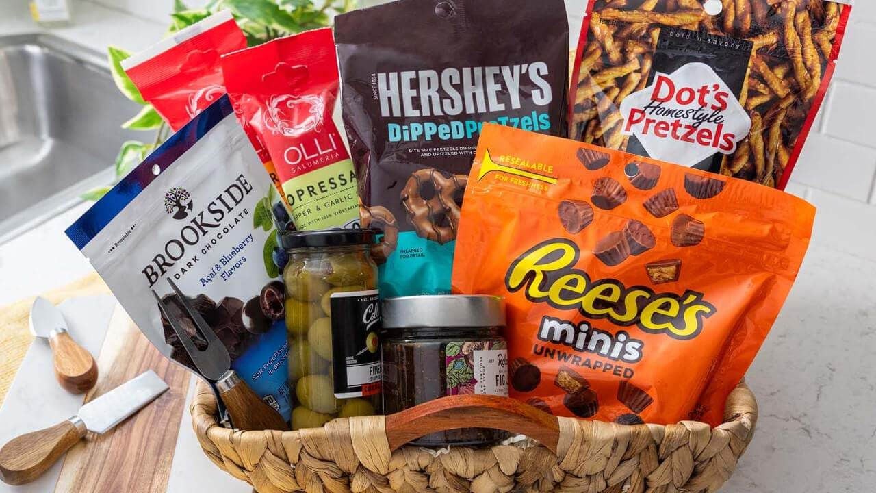 basket filled with olives, seasonings, and assorted hersheys candy and snacks