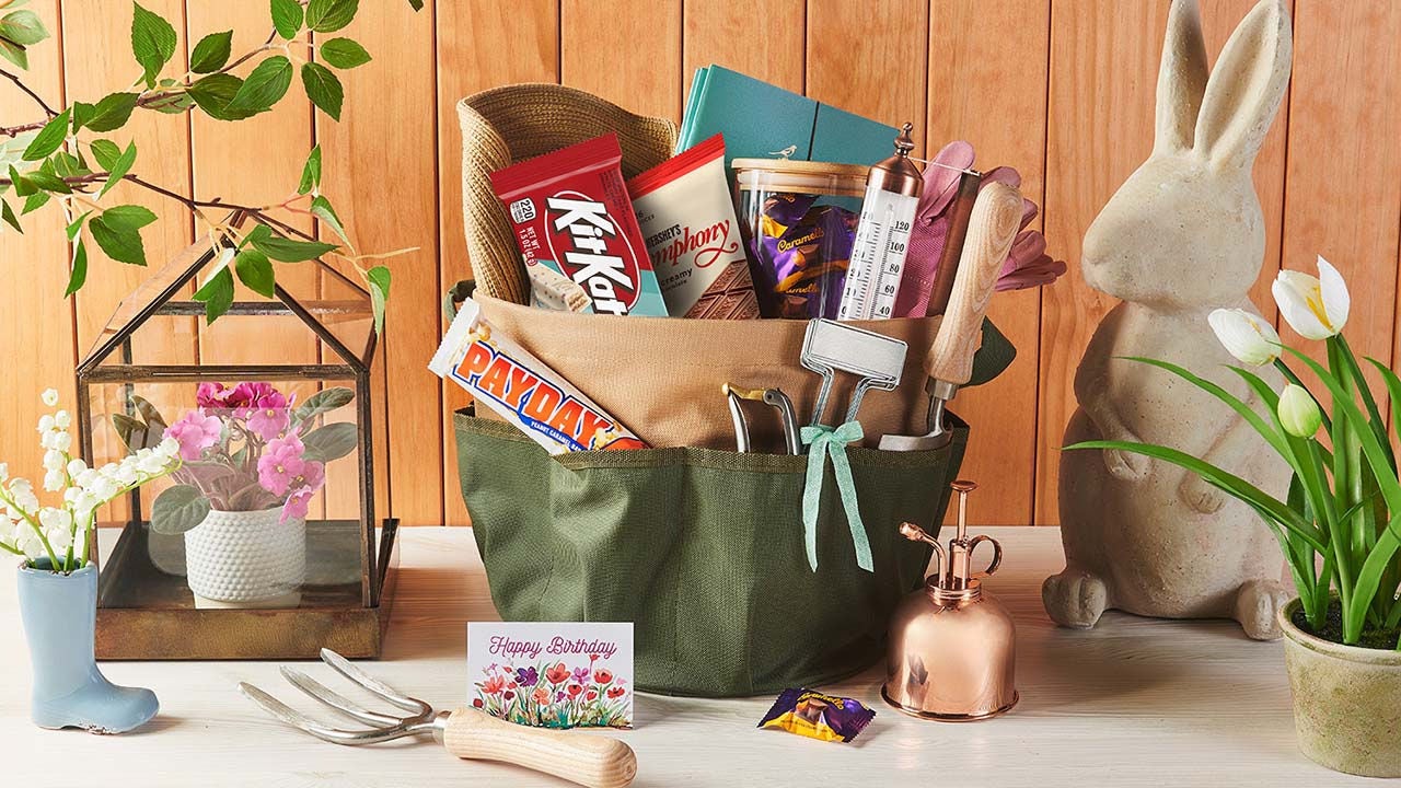 basket filled with seed packets, watering can, plant markers, and assorted hersheys candy