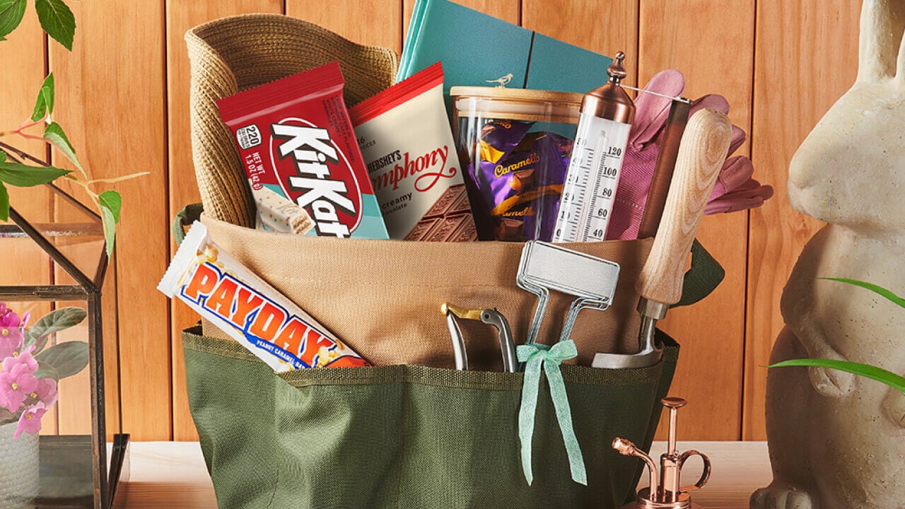 basket filled with seed packets, watering can, plant markers, and assorted hersheys candy