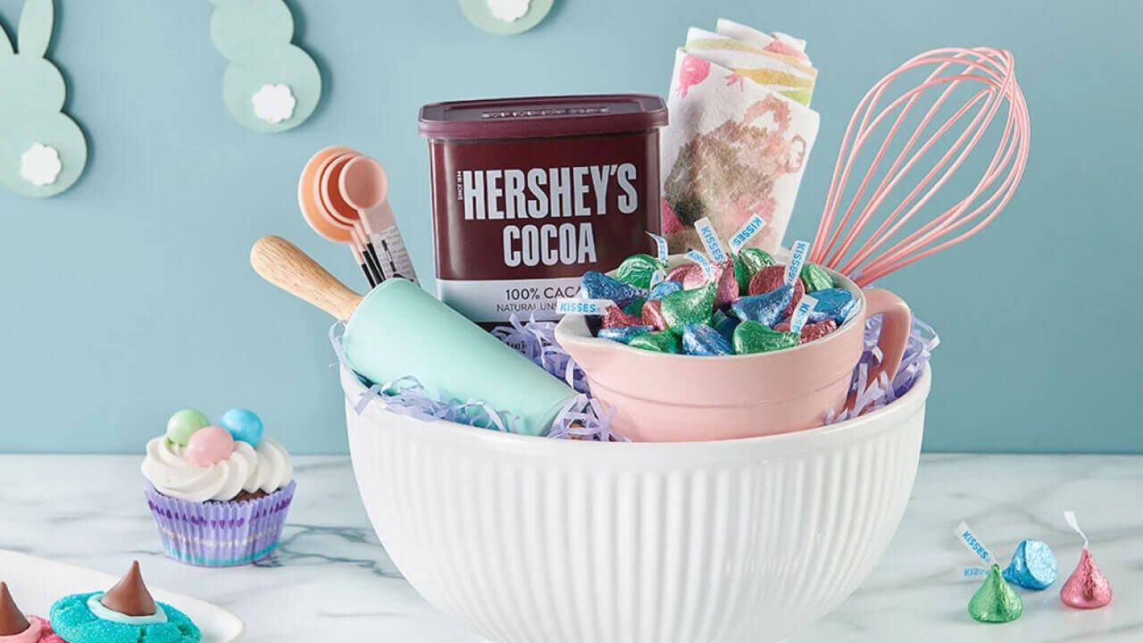 basket filled with measuring cups, spoons, spatulas, and assorted hersheys baking products