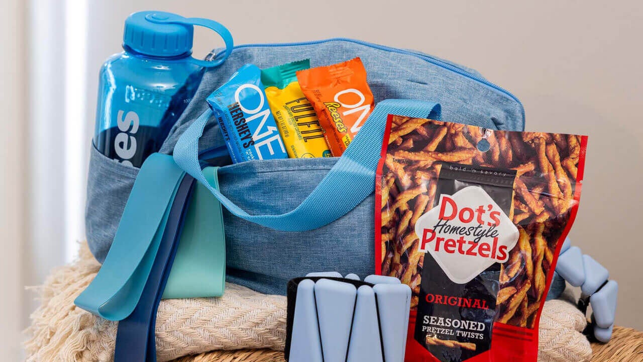 basket filled with water bottle, resistance bands, and assorted hersheys candy and protein bars