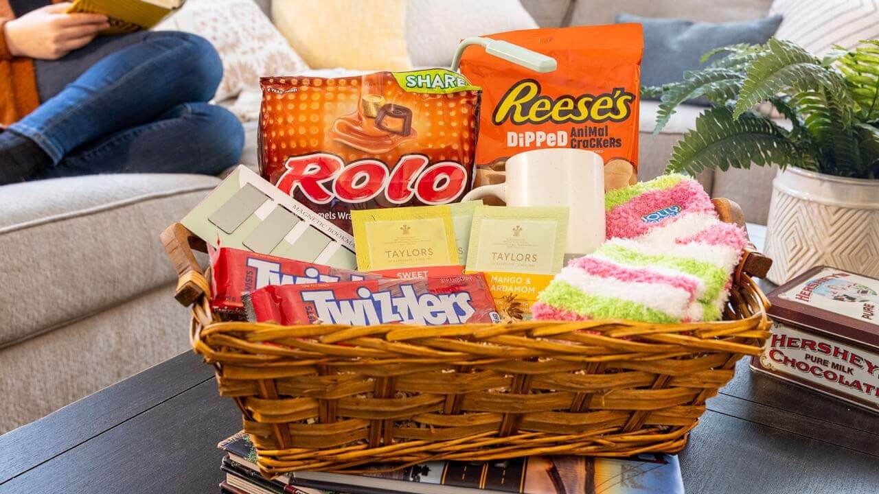 basket filled with socks, book markers, mugs, and assorted hersheys candy