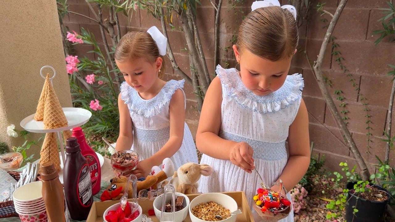 two little girls making ice cream sundaes at a sundae bar