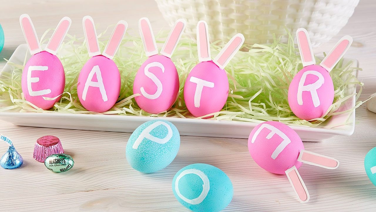 pink and blue dyed easter eggs painted with white letters