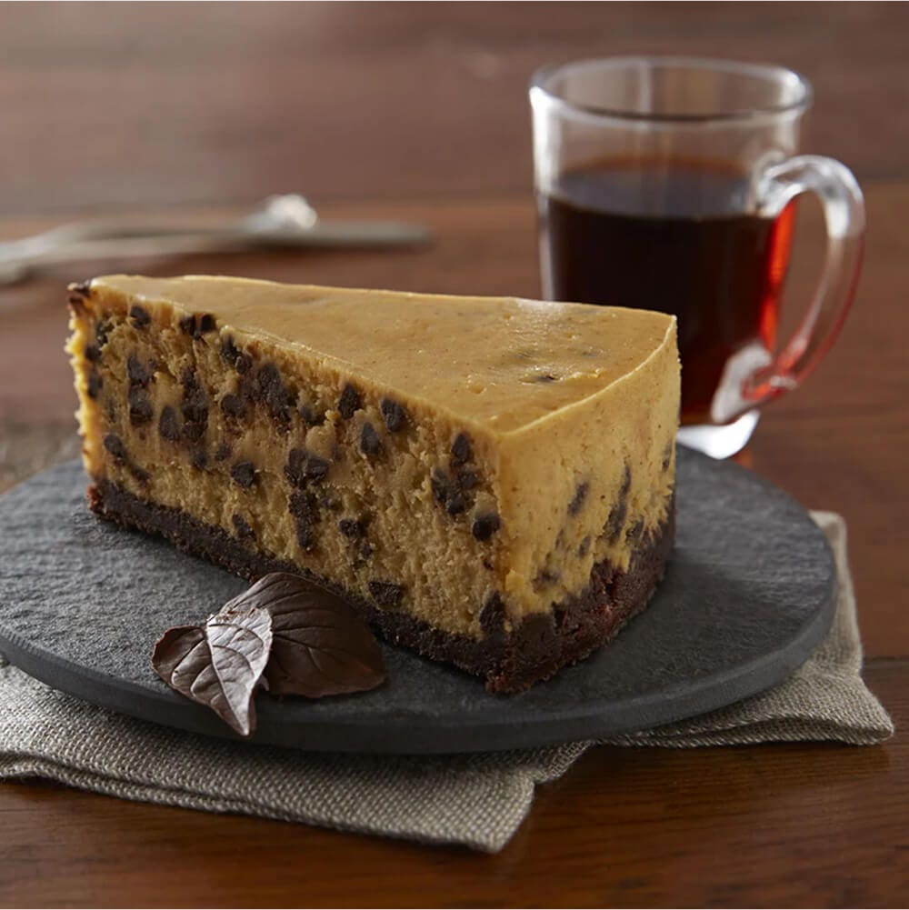 slice of chocolate chip pumpkin cheesecake with mug of coffee