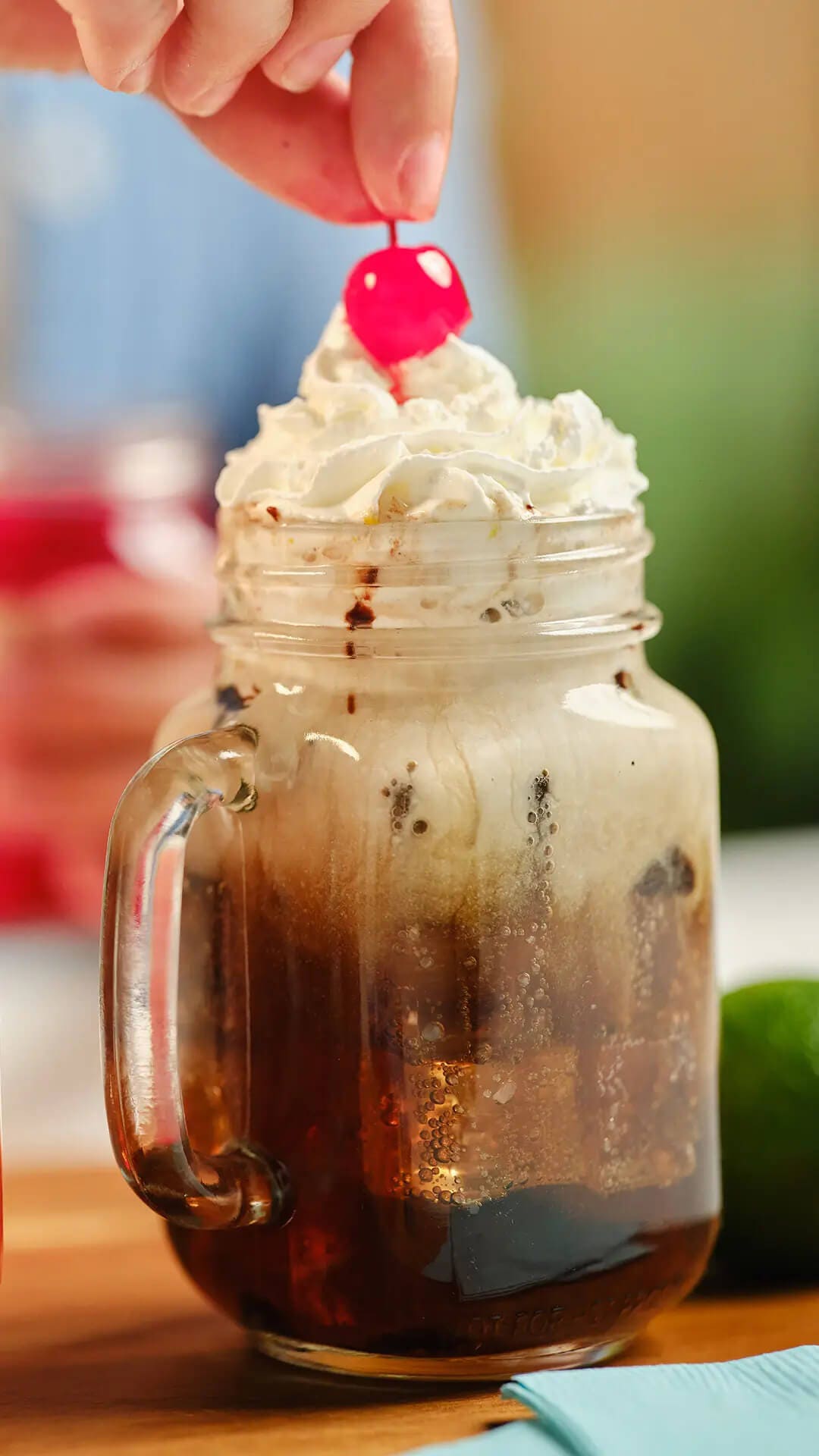 dirty soda topped with whipped cream and a cherry