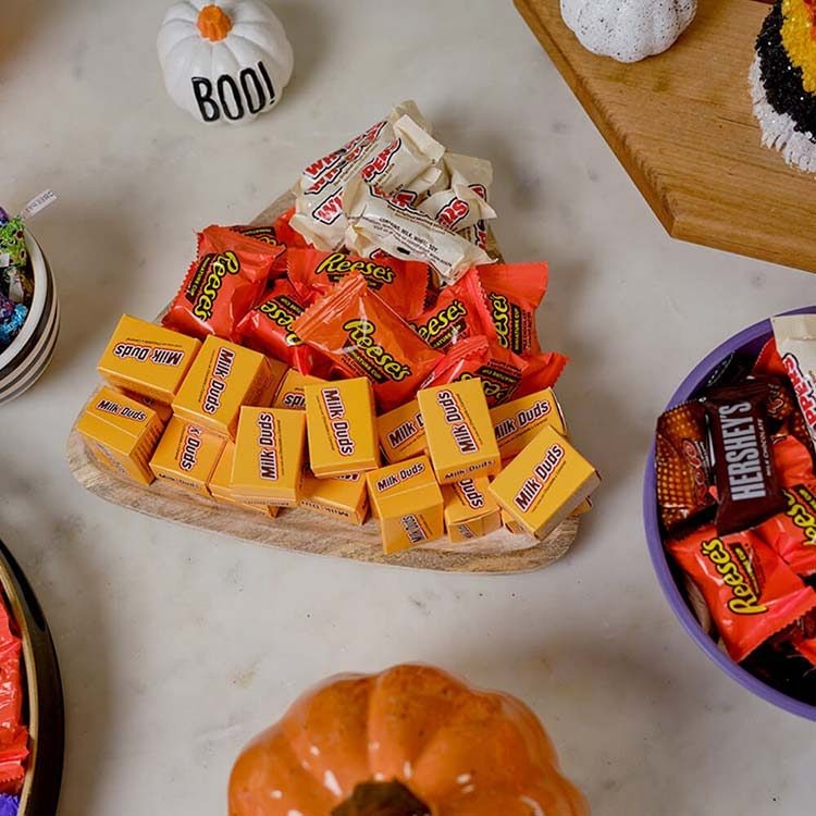 candy corn themed candy dish filled with assorted hersheys candies