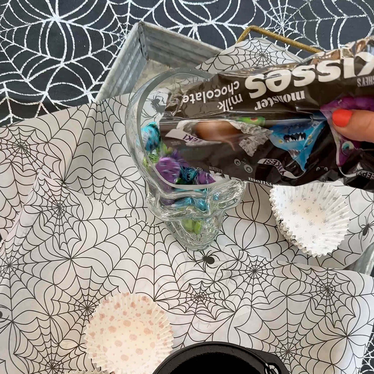 glass skull being filled with halloween hersheys kisses