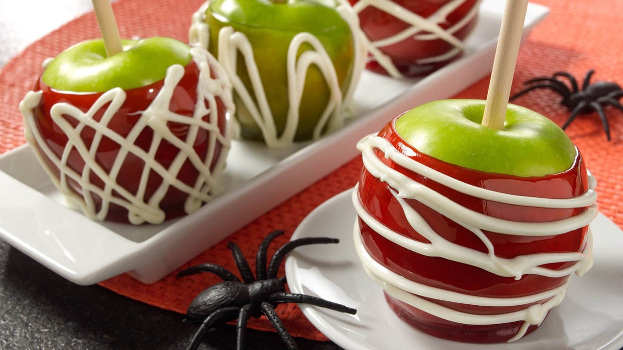 caramel and candy apples decorated with icing spiderwebs