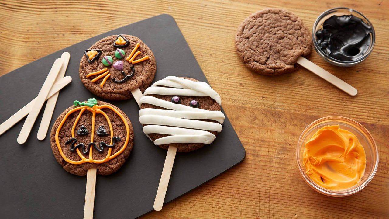 cookies on a stick decorated to look like different halloween creatures