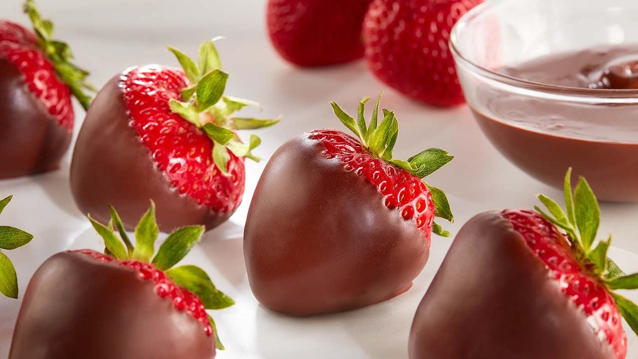 batch of chocolate covered strawberries cooling on wax paper