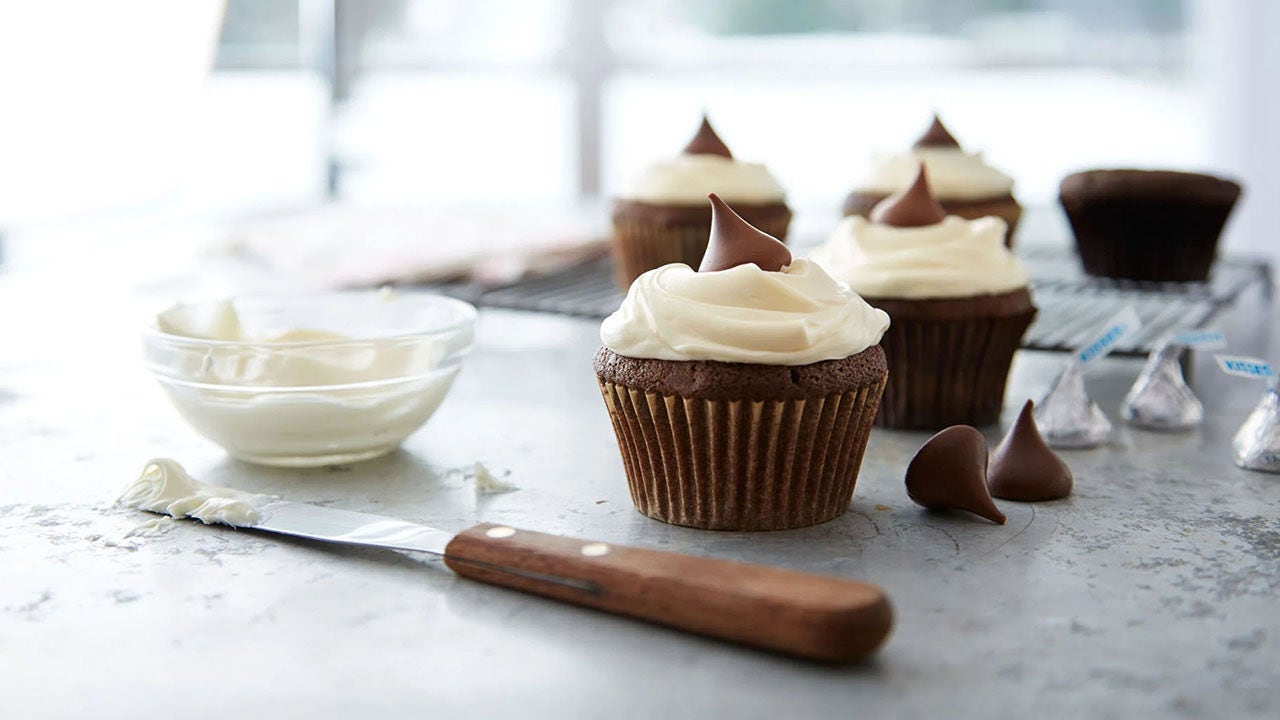 topping chocolate cupcakes with vanilla frosting and hersheys kisses milk chocolates