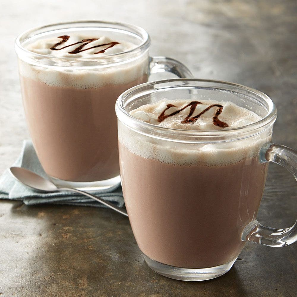 mugs of hot chocolate mocha topped with chocolate syrup