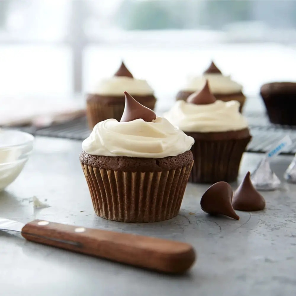 iced cupcakes topped with hershey kisses