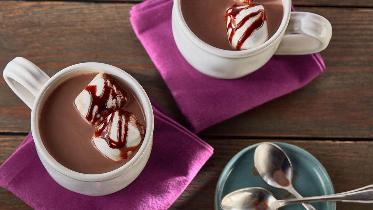 mugs of hot chocolate with hershey's syrup drizzle over marshmallows