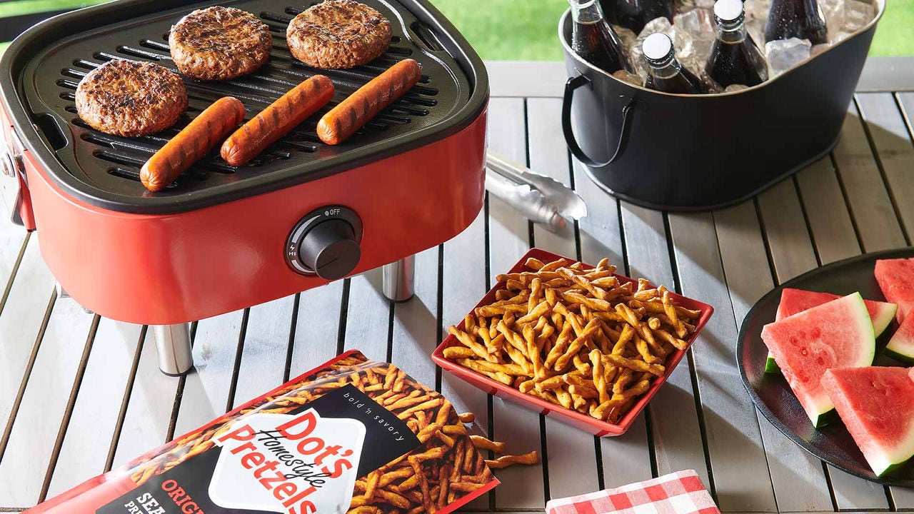 picnic table with grill and bowl of dots pretzels
