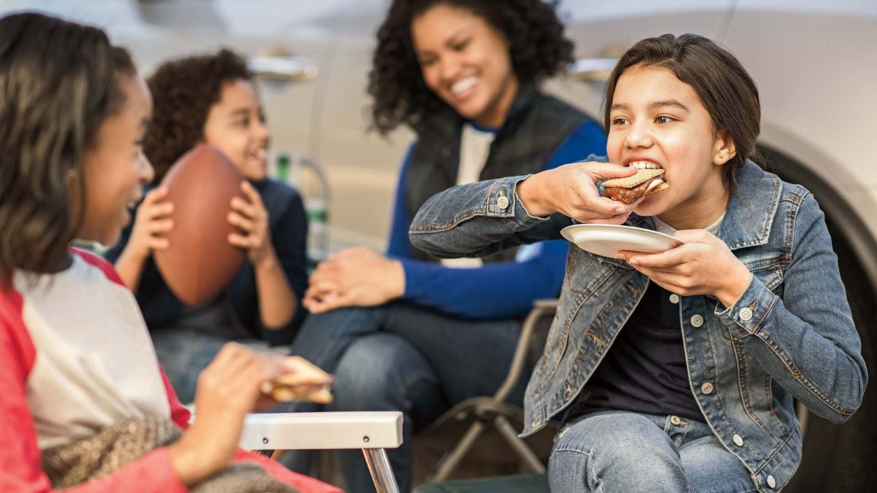 family eating smores at tailgate
