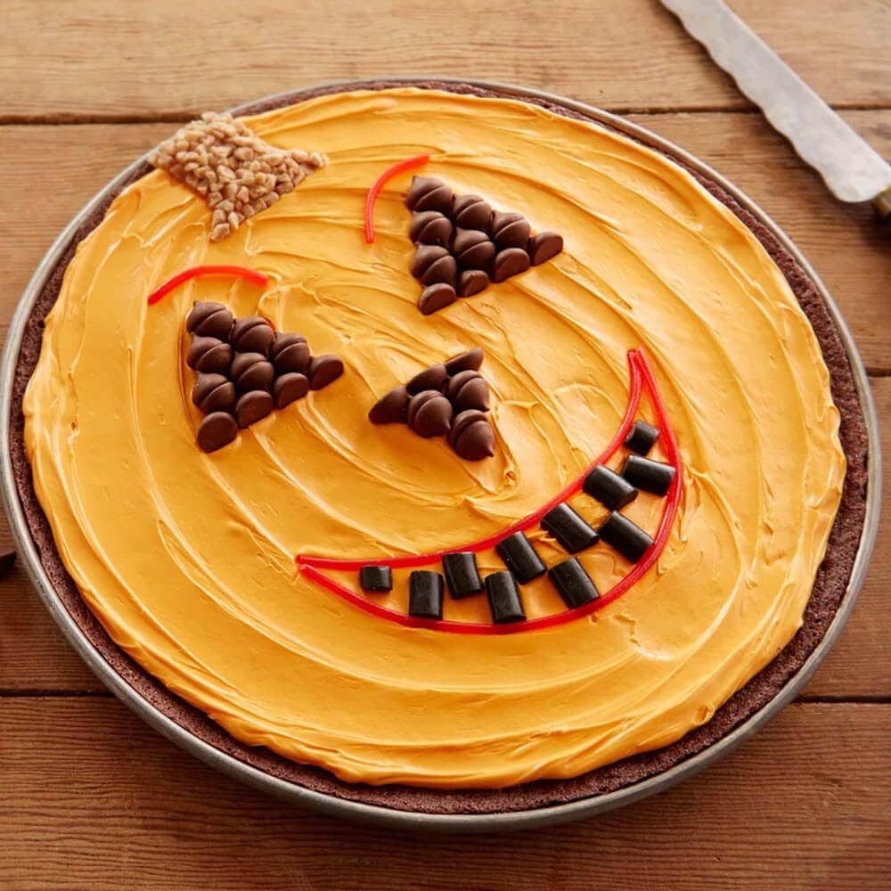 table topped with a jack o lantern brownie cake